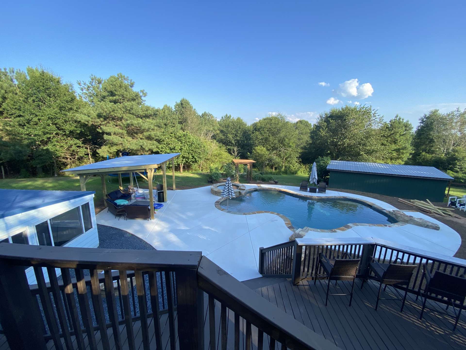 Photo of a pool from a deck with covered area