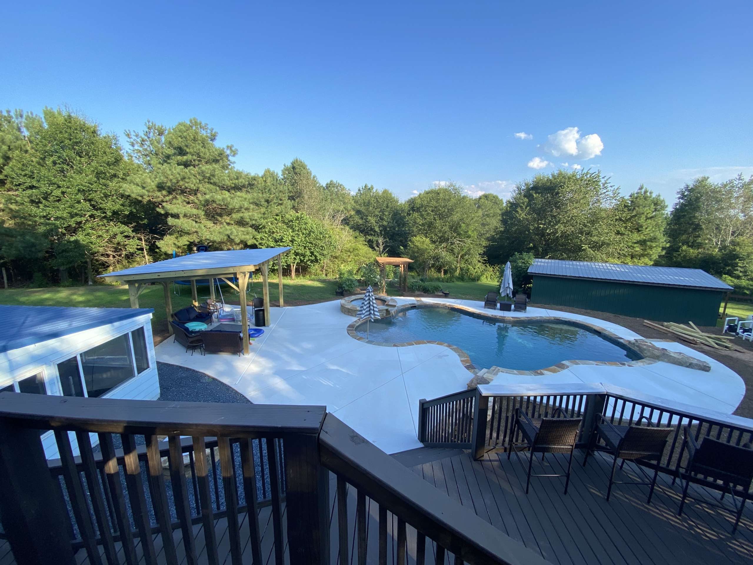 Photo of a pool from a deck with covered area